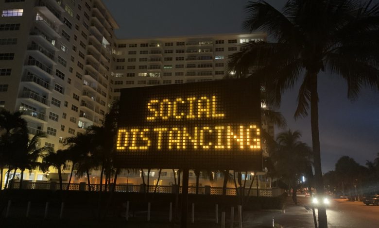 Panneau lumineux demandant la distanciation sociale face à la plage de Pompano Beach en Floride