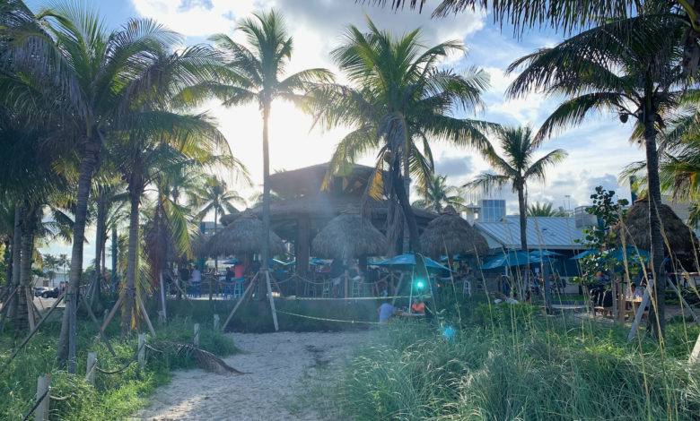 Coucher de soleil su le tiki-bar "Lucky Fish" de la plage de Pompano Beach en Floride