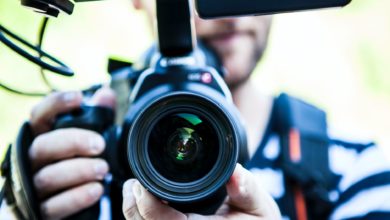 person holding canon dslr camera close up photo