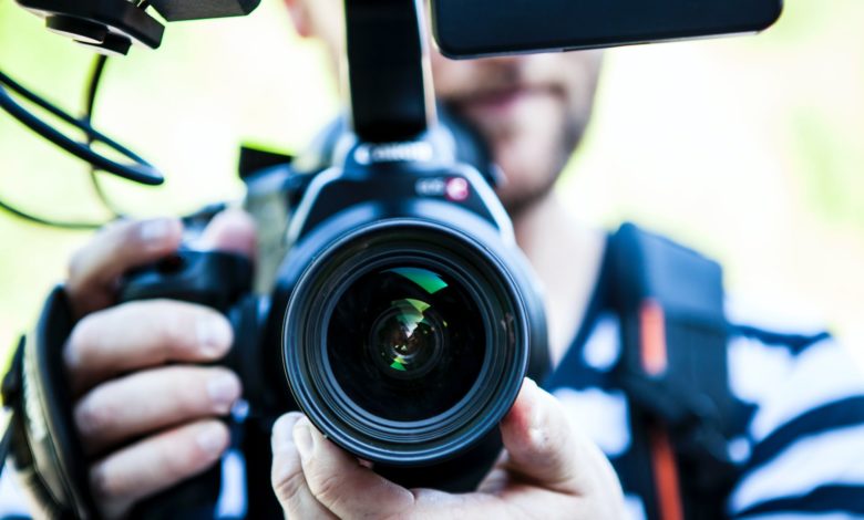 person holding canon dslr camera close up photo