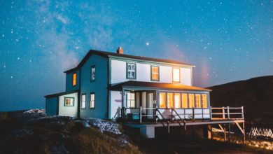white and brown wooden house on hill under blue sky during night time