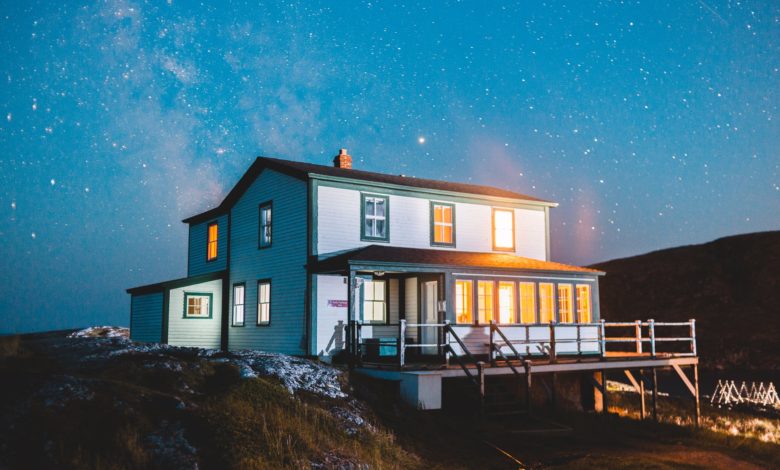 white and brown wooden house on hill under blue sky during night time