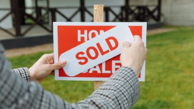 shallow focus photo of a realtor posting a sold sticker