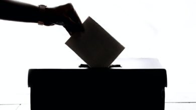 person dropping paper on box