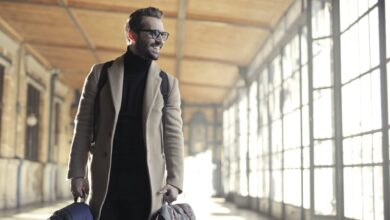 man in brown robe carrying bag smiling