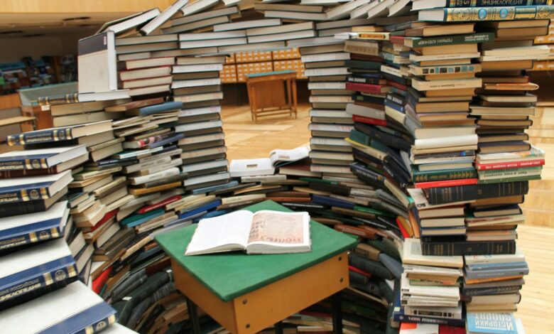 a room filled with lots of books on top of a wooden floor