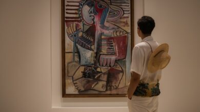 A man looking at a painting in a museum