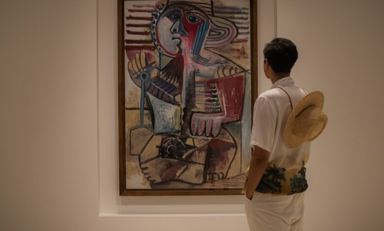 A man looking at a painting in a museum