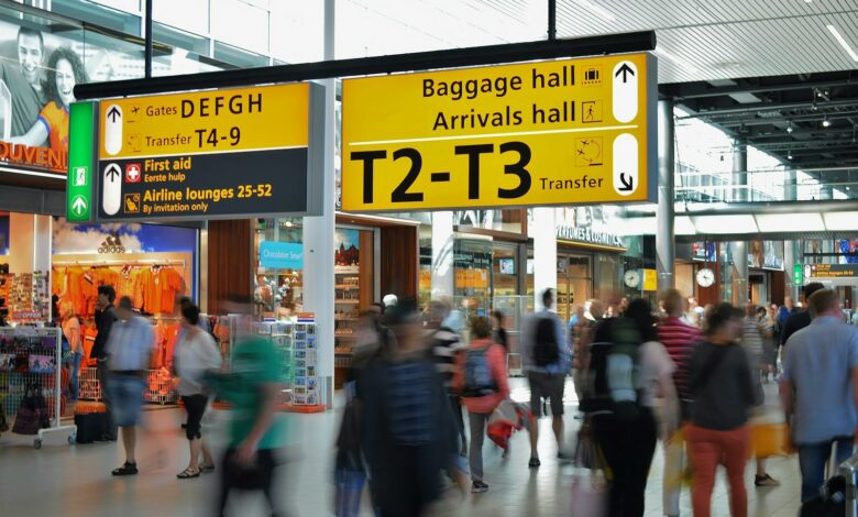 Crowded airport with motion blur and clear signage indicating baggage and arrival halls.