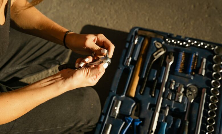 Close-up of hands using tools from a toolset in a well-lit workshop setting.